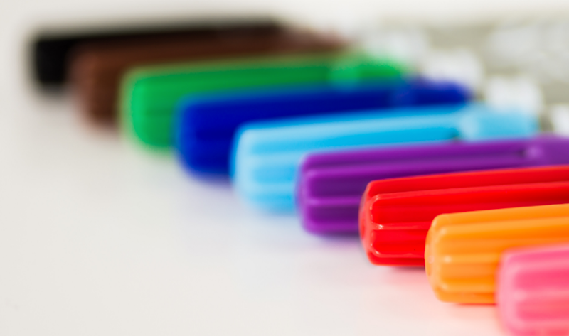 A closeup of markers lined up on a surface