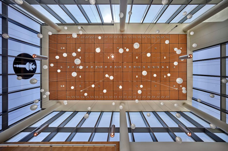 Lighting hanging from a double-height lobby space in the Rohrer College of Business facility